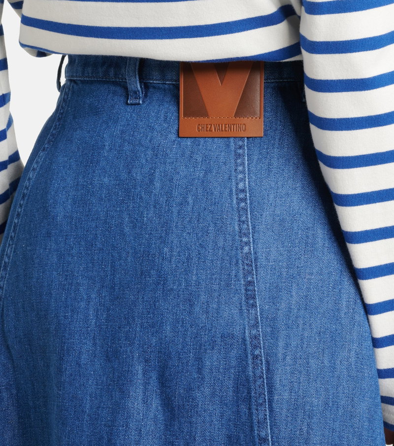 Blue denim skirt with a brown leather Valentino belt buckle.