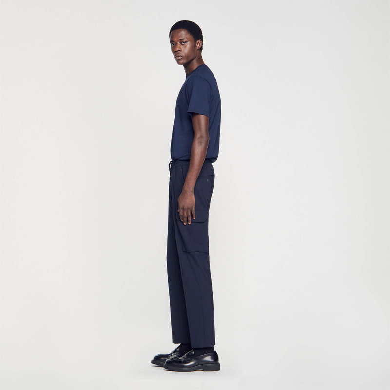 Man in navy t-shirt and trousers, side view