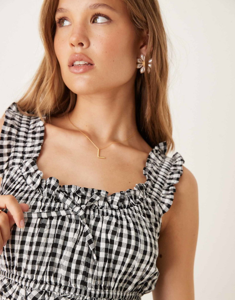 Black and white gingham top, styled with gold jewelry on a model.