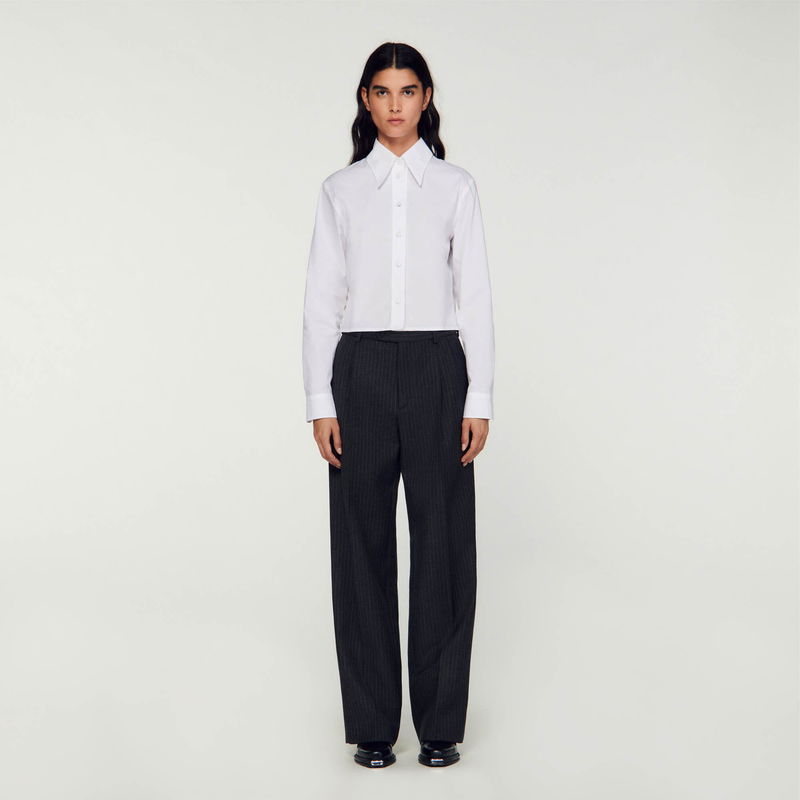 Sandro: Man in a white shirt and wide-legged pinstripe trousers.