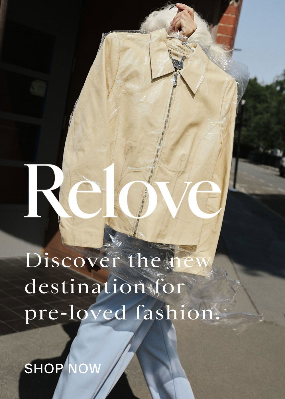 Person holding butter yellow leather jacket in dry-cleaning plastic