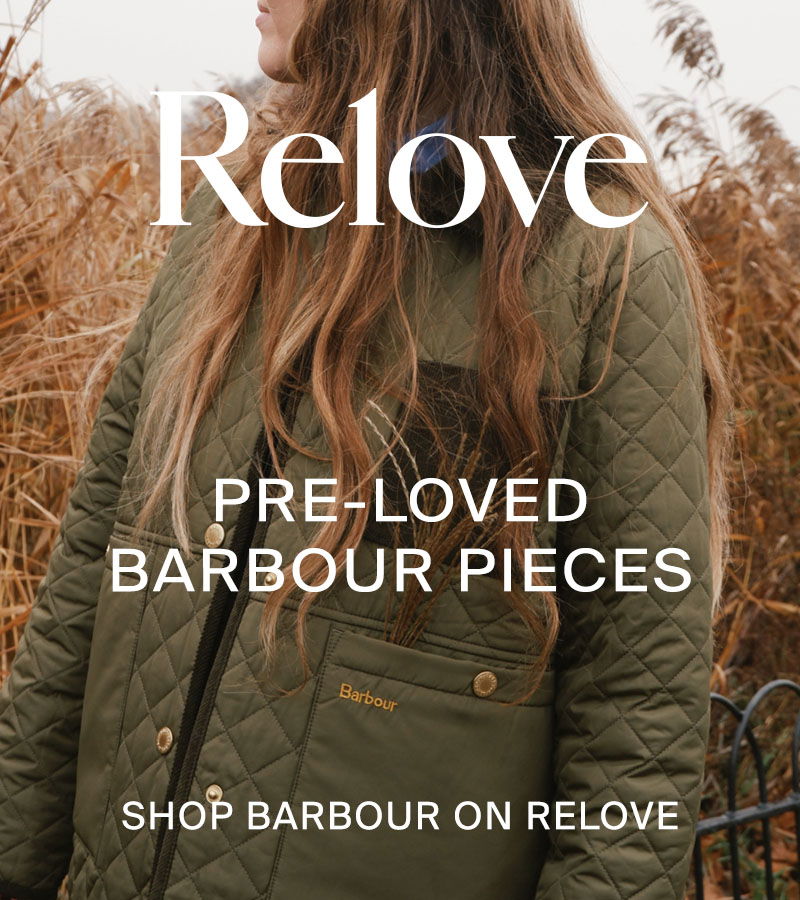 Woman in field wearing green Barbour jacket