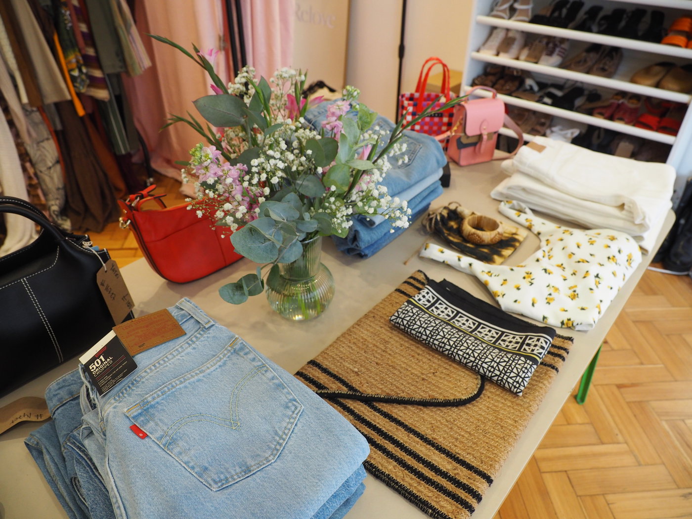 Table laid with flowers, jeans and fashion accessories